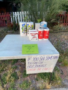 table with paper goods and a sign that says if you see something you can use help yourself